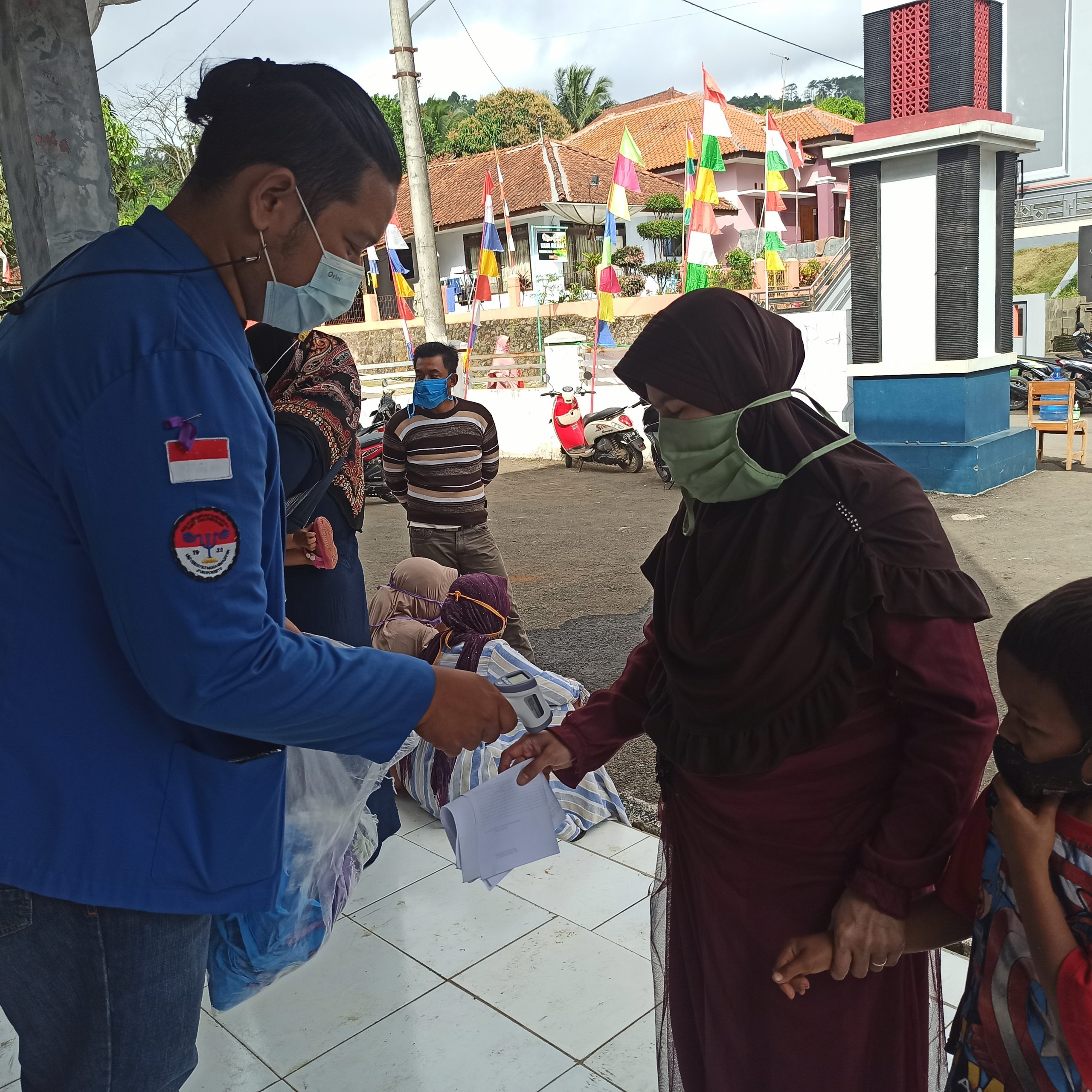 Pengecakan suhu tubuh pada warga desa Tembongraja yang akan melakukan vaksinisasi